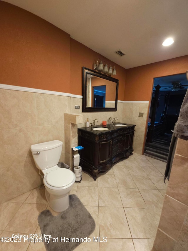 bathroom with vanity, tile patterned flooring, toilet, and tile walls