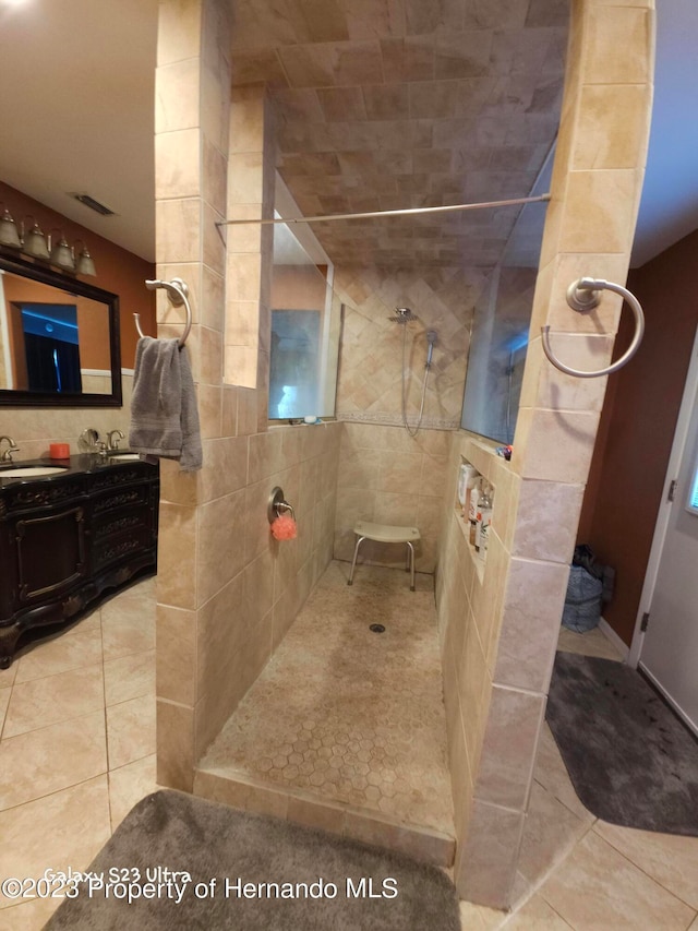 bathroom with walk in shower, tile walls, vanity, and tile patterned floors