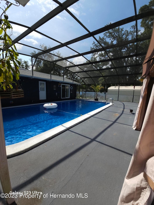 view of pool featuring glass enclosure