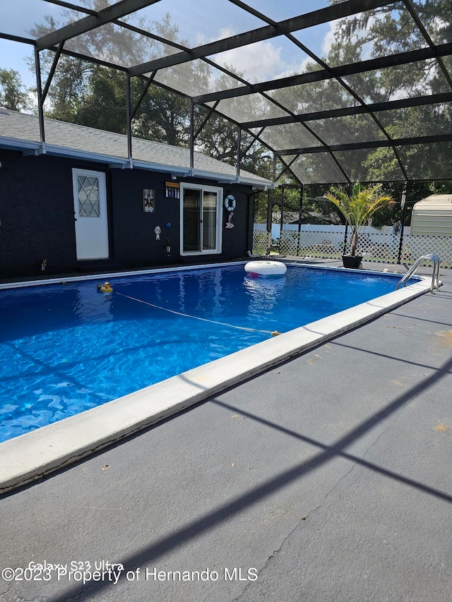 view of swimming pool with glass enclosure