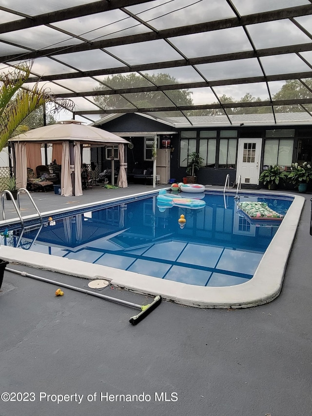 view of pool with a lanai, a patio, and a gazebo