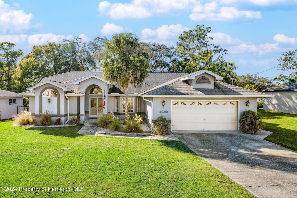 single story home with a front yard and a garage