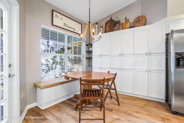 dining room with light hardwood / wood-style floors and a chandelier