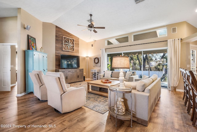 living room with hardwood / wood-style flooring, high vaulted ceiling, and ceiling fan