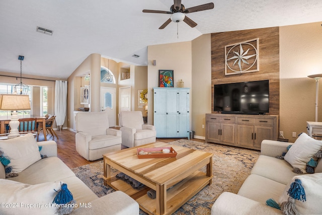 living room with lofted ceiling, ceiling fan, and light hardwood / wood-style flooring