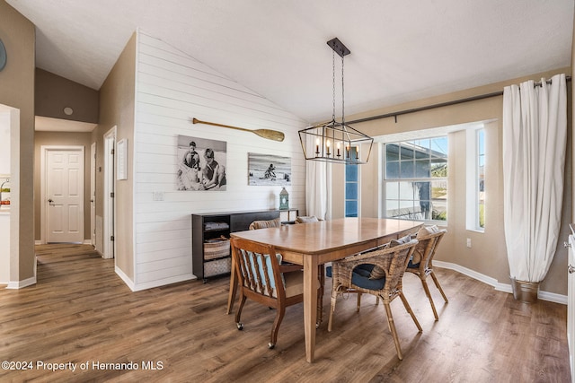 dining room featuring vaulted ceiling, dark hardwood / wood-style floors, and an inviting chandelier