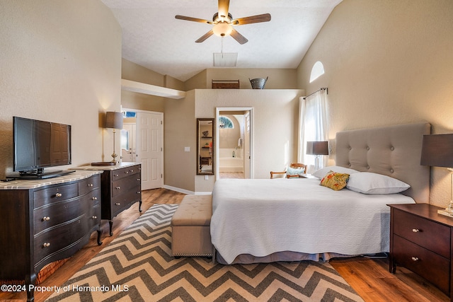 bedroom with high vaulted ceiling, ensuite bath, and wood-type flooring