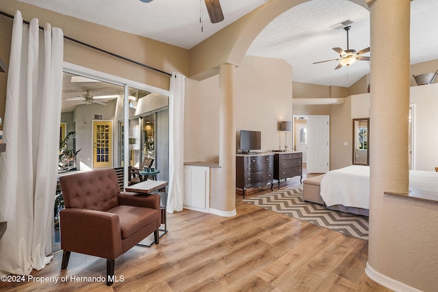 bedroom featuring ornate columns, lofted ceiling, ceiling fan, and light hardwood / wood-style flooring