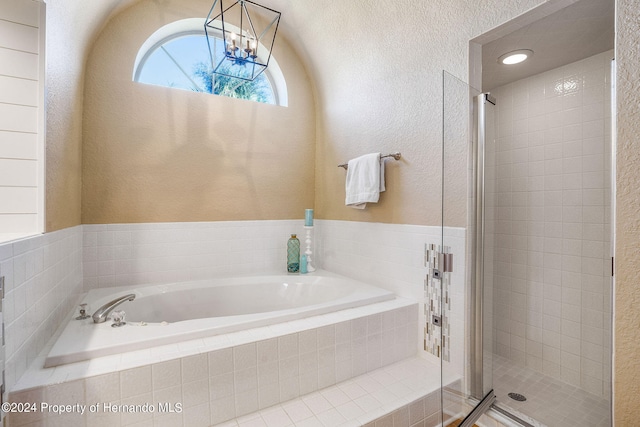 bathroom featuring separate shower and tub and a chandelier