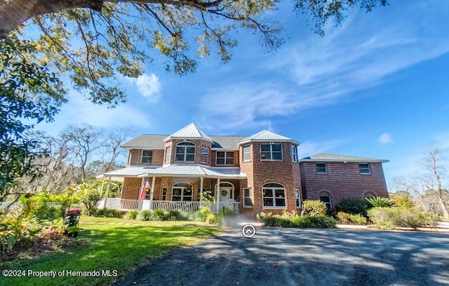 view of front of property featuring a front yard and covered porch