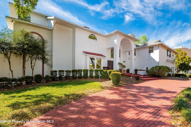 11915 W Riverhaven Dr, Homosassa, FL 34448 - mediterranean / spanish-style home with stucco siding and a front lawn