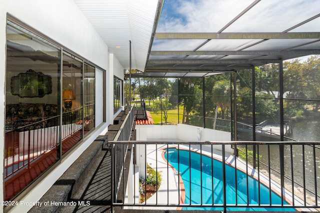 view of swimming pool featuring glass enclosure