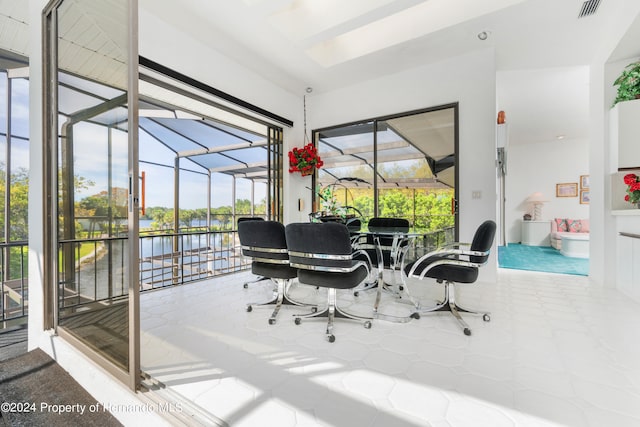 interior space featuring tile patterned flooring, a healthy amount of sunlight, and a water view