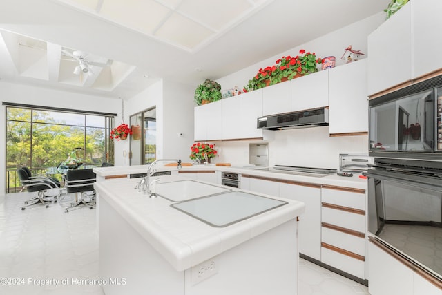 11915 W Riverhaven Dr, Homosassa, FL 34448 - kitchen with a sink, under cabinet range hood, tile countertops, a ceiling fan, and black appliances