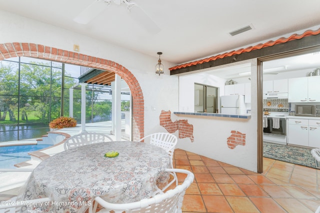 11915 W Riverhaven Dr, Homosassa, FL 34448 - dining space with a ceiling fan, light tile patterned flooring, and a water view