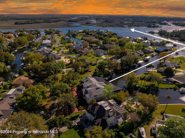 aerial view at dusk featuring a water view