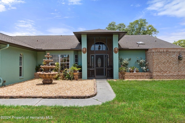 property entrance featuring a lawn