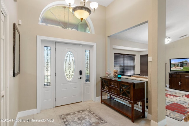 entryway featuring a notable chandelier and light tile patterned flooring