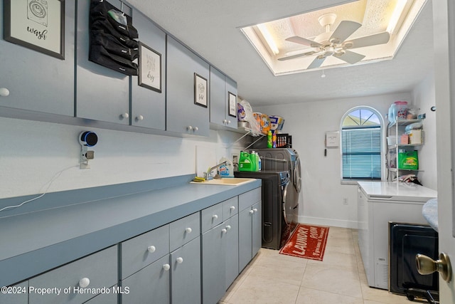 laundry room featuring a textured ceiling, light tile patterned floors, cabinets, washer and dryer, and ceiling fan