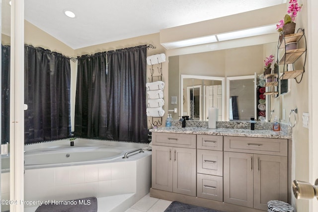 bathroom with vanity, tiled tub, tile patterned floors, and lofted ceiling