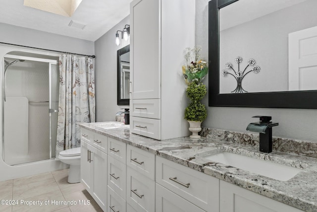 bathroom with toilet, vanity, tile patterned flooring, and curtained shower