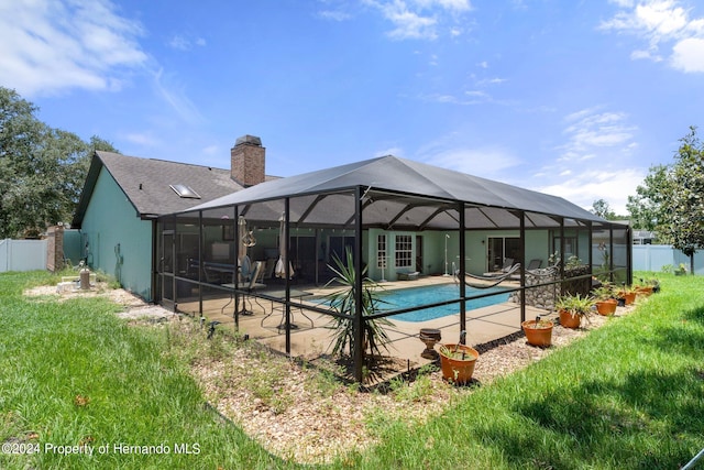 view of pool with a patio area, a yard, and a lanai