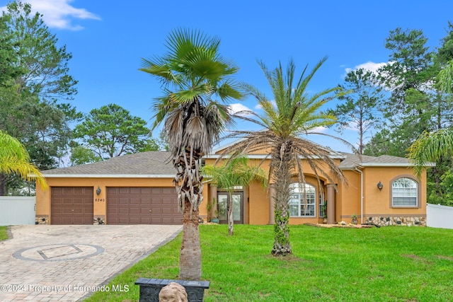 single story home featuring a garage, french doors, and a front lawn