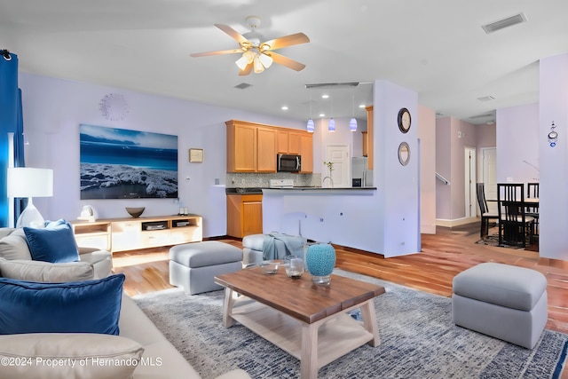 living room featuring light wood-type flooring and ceiling fan