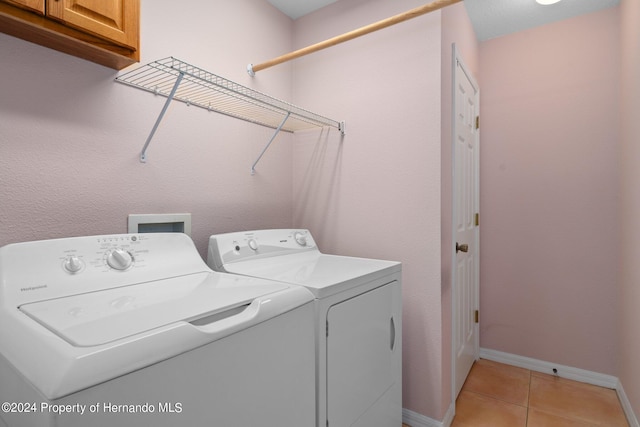 laundry area featuring cabinets, independent washer and dryer, and light tile patterned flooring