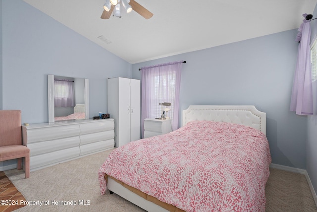 carpeted bedroom with multiple windows, vaulted ceiling, and ceiling fan