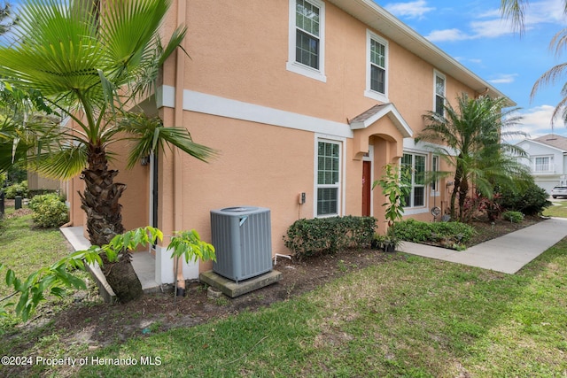 view of front of property with cooling unit and a front yard