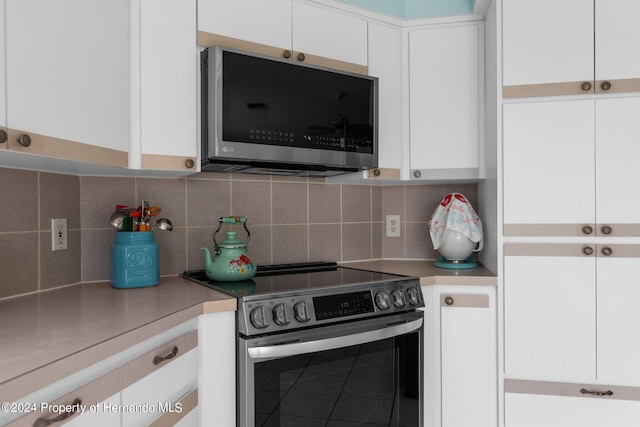 kitchen with appliances with stainless steel finishes, decorative backsplash, and white cabinets