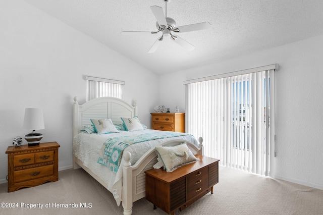 bedroom featuring ceiling fan, a textured ceiling, light carpet, and lofted ceiling