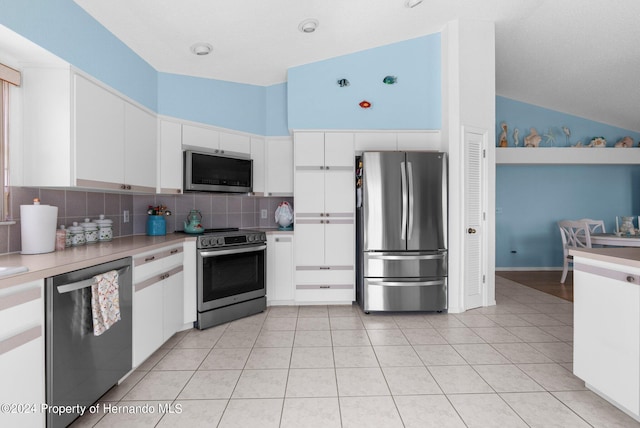 kitchen featuring tasteful backsplash, appliances with stainless steel finishes, and white cabinets