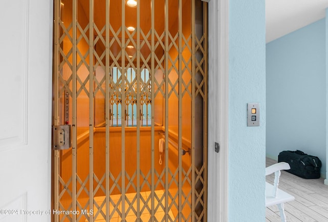 room details featuring elevator and wood-type flooring