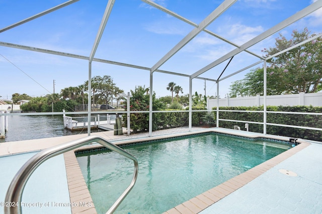 view of pool featuring a water view, glass enclosure, and a patio