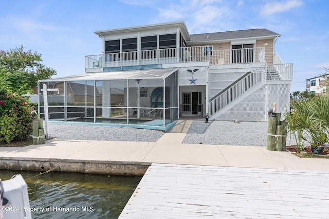 rear view of house with a pool, a water view, and a patio area