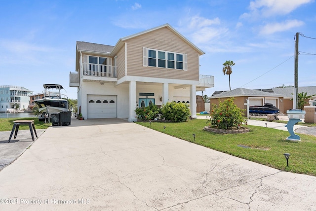 view of front of house with a garage, a front lawn, and a balcony