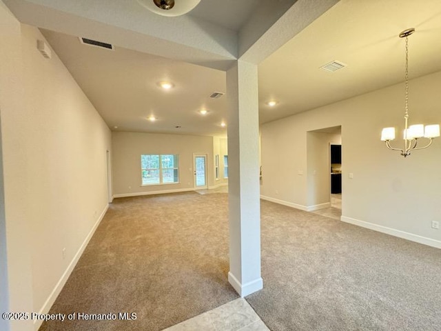 interior space featuring carpet and a chandelier