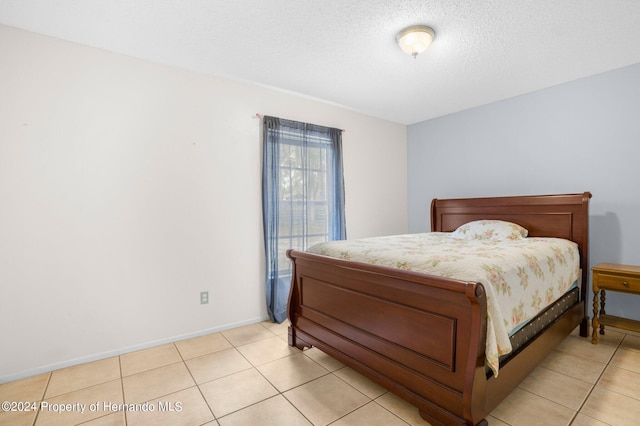 bedroom featuring a textured ceiling and light tile patterned floors