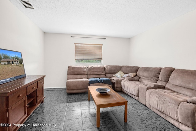 living room with a textured ceiling and tile patterned flooring