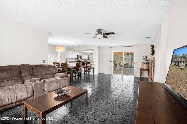 living room with ceiling fan and tile patterned floors