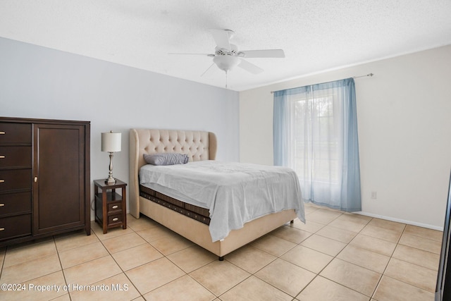 bedroom featuring a textured ceiling, ceiling fan, and light tile patterned flooring