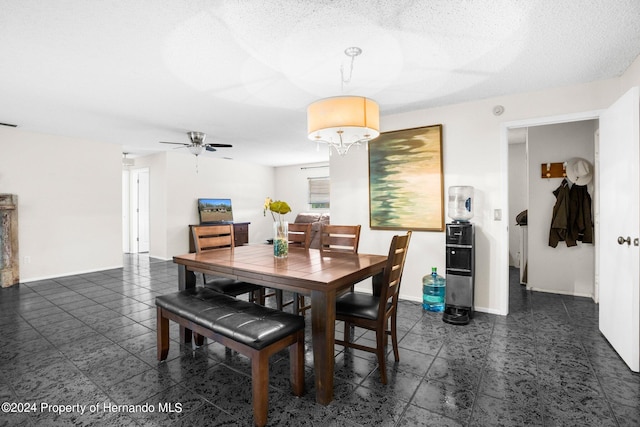 dining area featuring ceiling fan and a textured ceiling