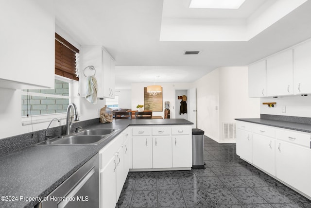 kitchen with white cabinets, kitchen peninsula, sink, and decorative light fixtures