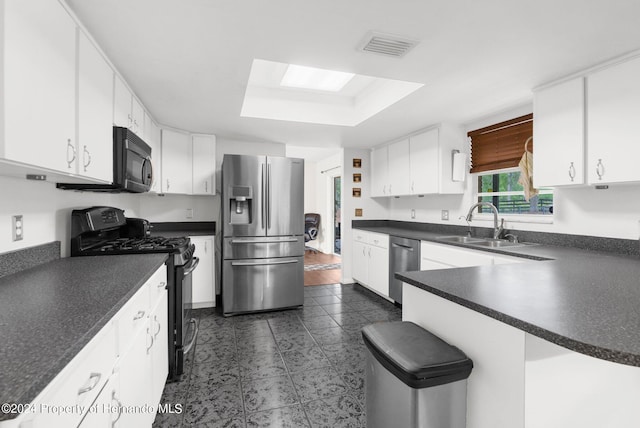 kitchen featuring dark tile patterned floors, white cabinets, sink, and stainless steel appliances