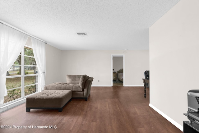 living area featuring a textured ceiling and dark hardwood / wood-style floors