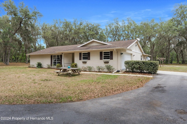 ranch-style house with a garage and a front yard