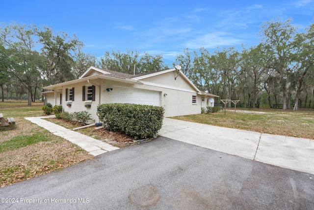 view of property exterior with a garage and a lawn