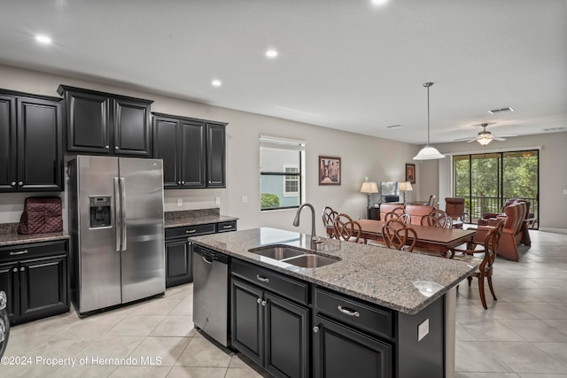 kitchen with a kitchen island with sink, sink, ceiling fan, appliances with stainless steel finishes, and decorative light fixtures